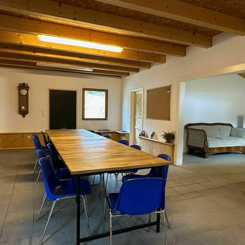 Der Tagungsraum des Freilufthauses mit Tisch, Stühlen und dem Sofa.
